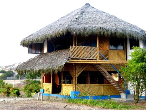 a hut with a thatched roof and a staircase at Wipeout Cabaña Restaurant in Las Tunas