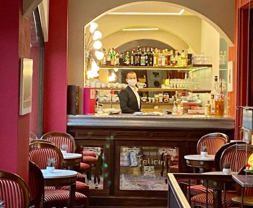a man standing behind the bar of a restaurant at Felicin - Ristorante Albergo "Dimora Storica" in Monforte dʼAlba