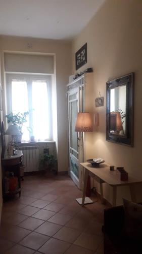 sala de estar con mesa y espejo en Le Stanze di Angela, en Nápoles