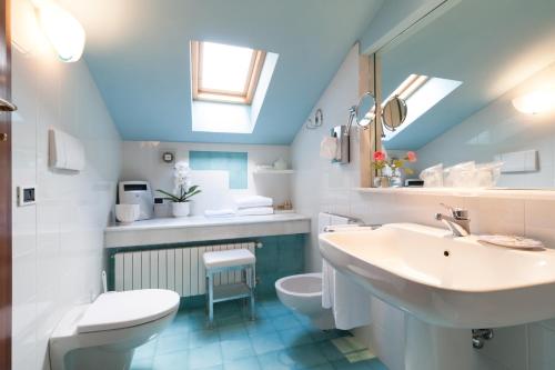 a blue and white bathroom with a sink and a toilet at Villa Abbazia Relais & Chateaux in Follina