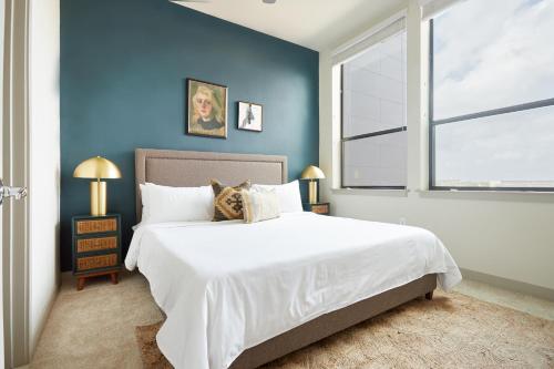 a bedroom with a large white bed and a blue wall at Sonder at La Villita in San Antonio