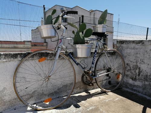 a bike parked next to a wall with buckets on it at Le Volte di Lo Re in Surbo