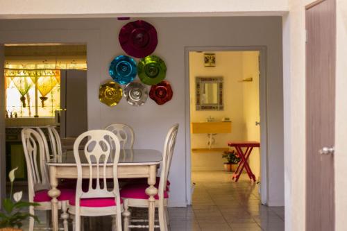 ein Esszimmer mit einem Tisch und Stühlen mit Ballons an der Wand in der Unterkunft Hostal Tlaquepaque in Guadalajara