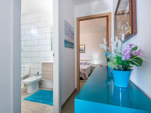 a bathroom with a blue counter with flowers on it at Sardinia SPA Apartment in Geremèas