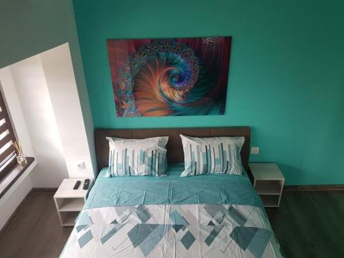a bedroom with a bed with a painting on the wall at Deluxe Aquamarine in Ahtopol