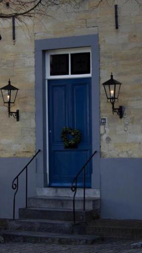 a blue door on a building with a window at Onder de Linde B&B in Valkenburg