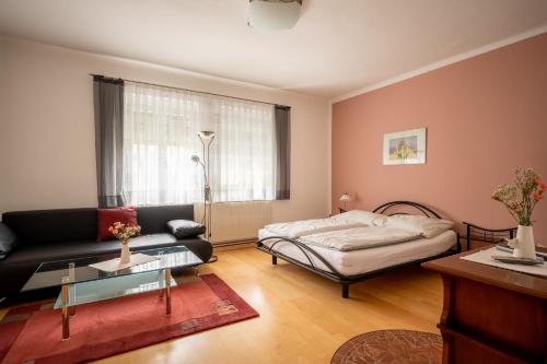 ein Wohnzimmer mit einem Sofa und einem Bett in der Unterkunft Winzerferienhaus Schüller in Purbach am Neusiedlersee