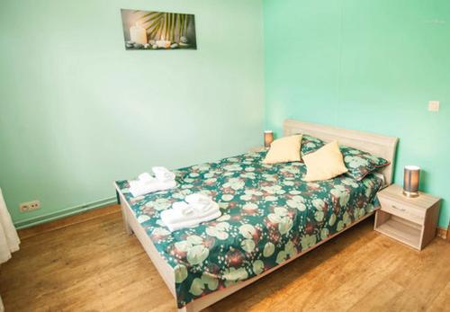 a bedroom with a bed with a green floral bedspread at Voisins du kayak in Dinant