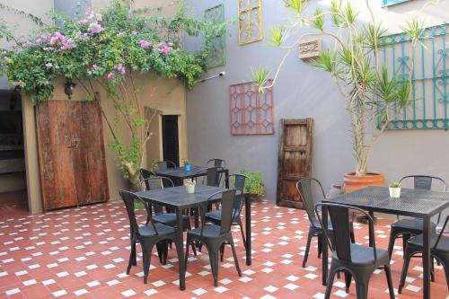 um restaurante com mesas e cadeiras num pátio em Entre Patios Hotel Boutique em León