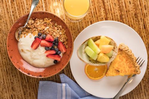
a white plate topped with fruit and a bowl of cereal at Hotel Indigo Asheville Downtown, an IHG Hotel in Asheville
