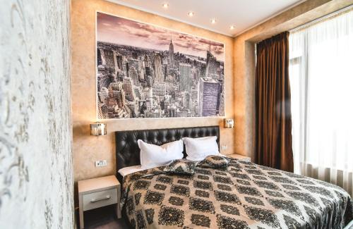 een slaapkamer met een bed en een schilderij aan de muur bij IMPERA Boutique Apartments in Constanţa