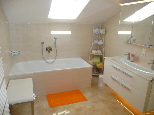 a bathroom with a bath tub and a sink at Alpenstern Ferienwohnung in Pfronten