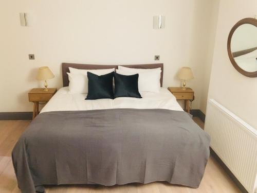 ロンドンにあるCLASSIC BRIXTON CITY APARTMENTのベッドルーム1室(大型ベッド1台、枕、鏡付)