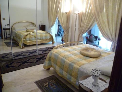 1 dormitorio con 2 camas y espejo en Villa Casa Gemelli, en Capolona