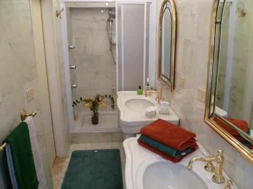 y baño blanco con lavabo y ducha. en Villa Casa Gemelli, en Capolona