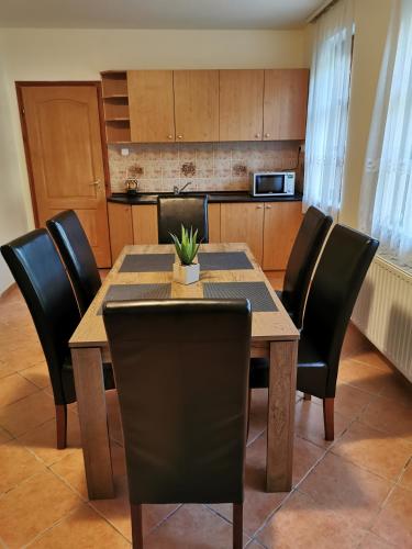 a dining room with a table and black chairs at Váralja Vendégház Tata in Tata