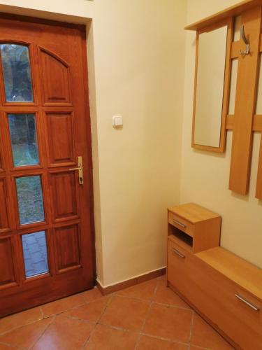a room with a door and a cabinet and a mirror at Váralja Vendégház Tata in Tata