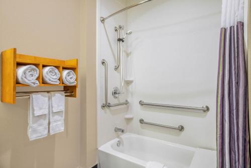 a bathroom with a tub and a toilet and towels at Spark by Hilton Little Rock West in Little Rock
