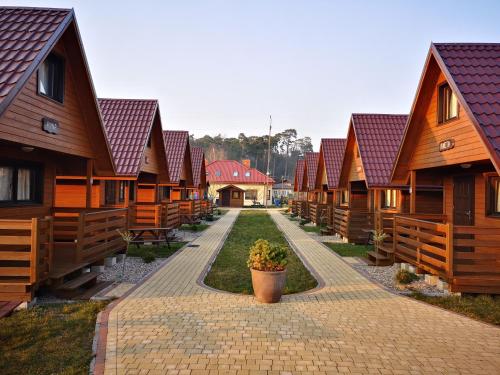 eine Reihe von Cottages aus Holz in Folge in der Unterkunft Domki Letniskowe "Przy Parku" in Wisełka