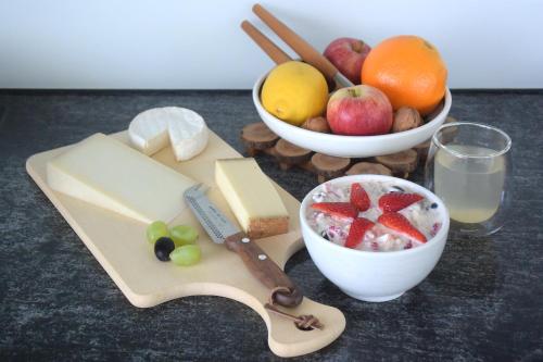 uma mesa coberta com queijo e uma taça de fruta em BnB 5430 em Wettingen