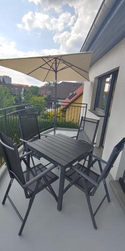 a table and two chairs and an umbrella on a balcony at Ferienwohnung Fink in Berlin