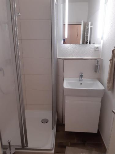 a white bathroom with a sink and a shower at Ferienwohnung Ostseeglück in Wendtorf