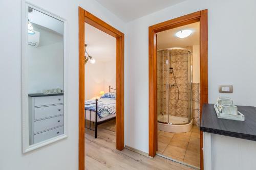 a bathroom with a walk in shower next to a bedroom at Villa Ana with jacuzzi & swimming pool in Cres