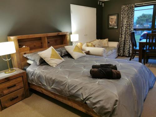 a bedroom with a large bed with a wooden headboard at Lakeview Holiday Hideaway in Taupo