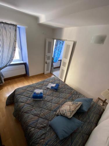 een slaapkamer met een groot bed met blauwe kussens erop bij La Dinette Riomaggiore in Riomaggiore