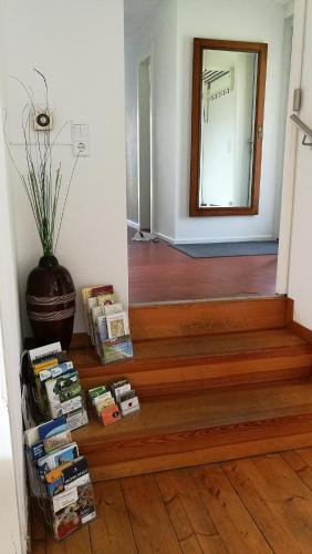 a hallway with stairs with a mirror and a vase at Ferienhaus Glücksmoment in Grasellenbach