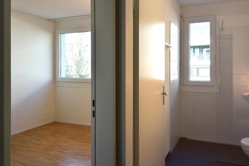 een lege badkamer met een toilet en een raam bij BnB 5430 in Wettingen