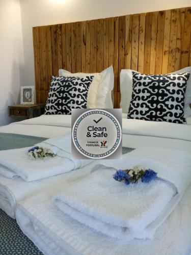 a hotel room with two beds with towels on them at Casa D Amélia in Óbidos