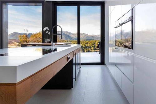 a kitchen with a large white counter and glass windows at Montblau in Búger