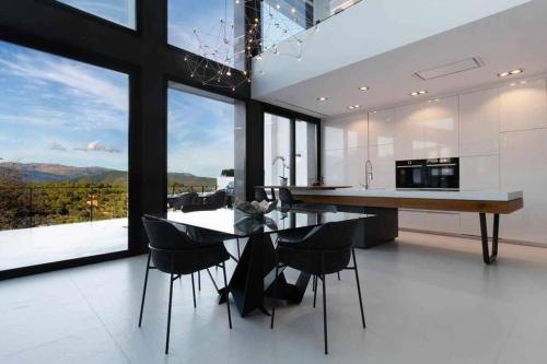 a kitchen with a table and chairs and a large window at Montblau in Búger