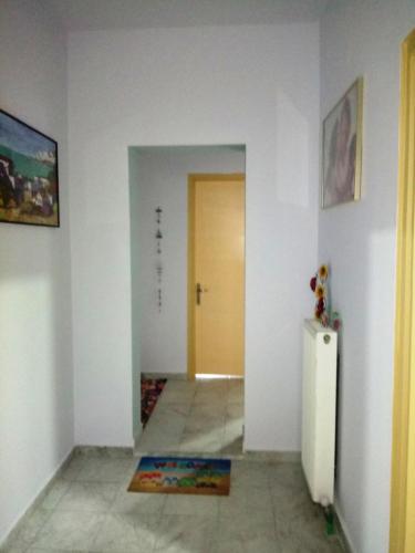 a room with a hallway with a door and a refrigerator at Ilio Socrates in Skala Marion