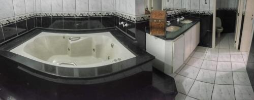 a large bath tub in a bathroom with a sink at Pousada Pedra das Tartarugas in São Francisco do Sul