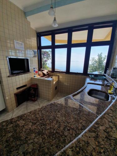 a bathroom with a sink and a tv in a room at Pousada Pedra das Tartarugas in São Francisco do Sul