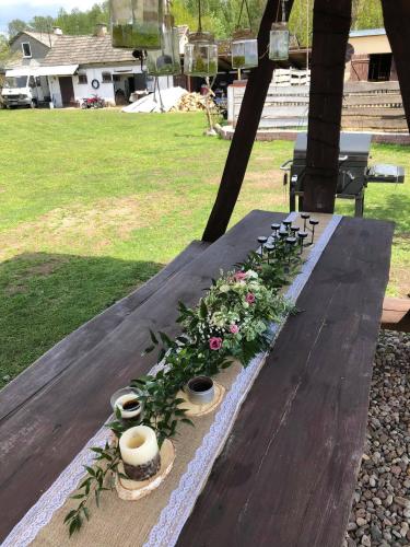 a wooden table with flowers and candles on it at Zamieszkaj na wsi blisko Warszawy in Borucza