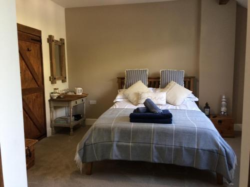 um quarto com uma cama com um cobertor azul em Guest Suite at 31 Little England em Milborne Saint Andrew