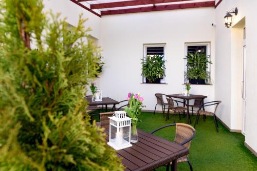 a patio with tables and chairs and plants at Tailor Hotel Sport & Conference in Morąg