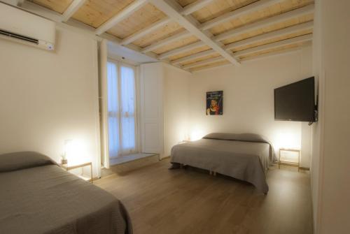 a bedroom with two beds and a flat screen tv at Monaciello in Naples