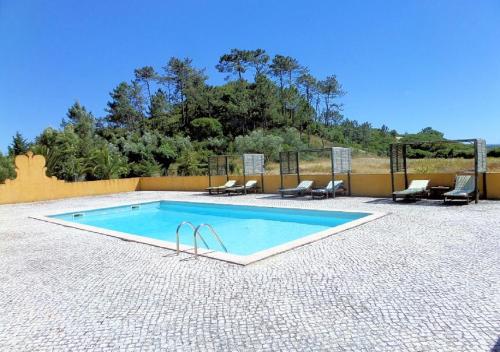 a swimming pool in a patio with chairs at Quinta Da Torre - Óbidos Country House in Óbidos