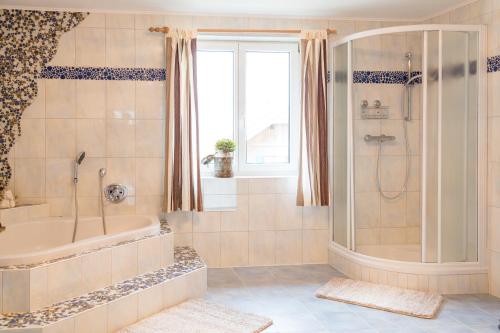 bagno con vasca e doccia. di Strauss Appartements a St. Wolfgang