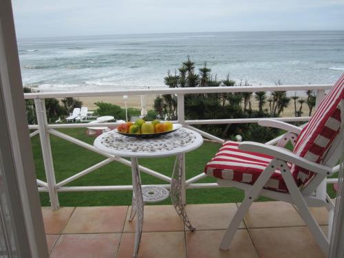 a bowl of fruit on a table on a balcony with the beach at Haus am Strand - on the Beach in Wilderness