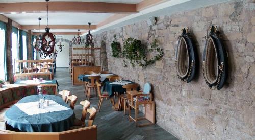 ein Restaurant mit Tischen und Stühlen und einer Steinmauer in der Unterkunft Landgasthof Probstei Zella in Frankenroda