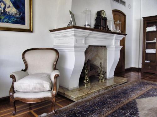 a chair in a living room with a fireplace at Solar De La Plaza in Salta