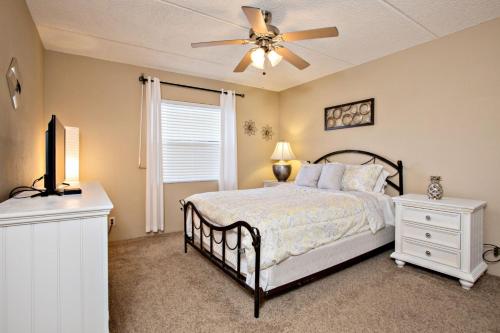 a bedroom with a bed and a ceiling fan at Ocean Watch Condo Unit #105 in Ormond Beach