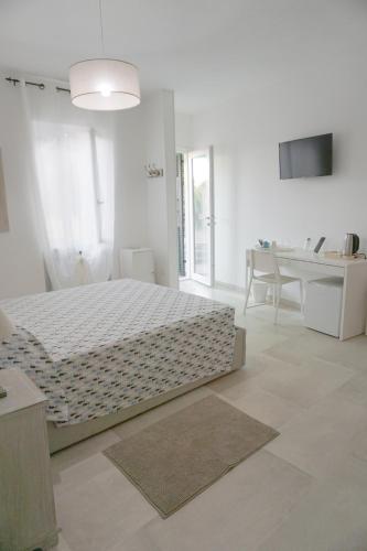 a white bedroom with a bed and a desk at Il Cavalluccio Marino in Manarola