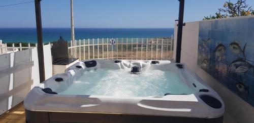 a jacuzzi tub on a balcony with the ocean at Villa Albuar in Albufeira