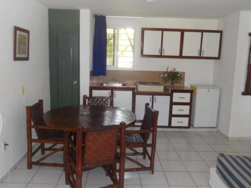 a dining room with a table and chairs and a kitchen at La Punta Apartamentos in Cabarete